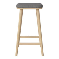 Wooden bar stool with natural finish and gray upholstered seat. Minimalist design, sleek lines, and neutral color palette.