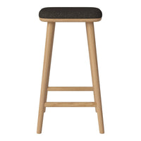 Black upholstered stool with natural wood legs, featuring a sleek and modern design. Ideal for kitchens or bars.