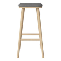 Light wood bar stool with a sleek gray upholstered seat, featuring a simple design and clean lines.