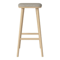 Light wooden bar stool with a soft gray upholstered seat, featuring a simple and modern design.