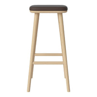 Brown upholstered stool with natural wood legs, featuring a minimalist design and smooth surfaces.