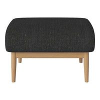 Black textured ottoman with a rounded top and natural wood legs, perfect for modern decor.