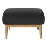 Black upholstered ottoman with a smooth surface and light wooden legs. Minimalist design complements modern decor.