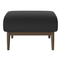 Black upholstered ottoman with a smooth texture and wooden legs. Elegant, modern design perfect for any decor.
