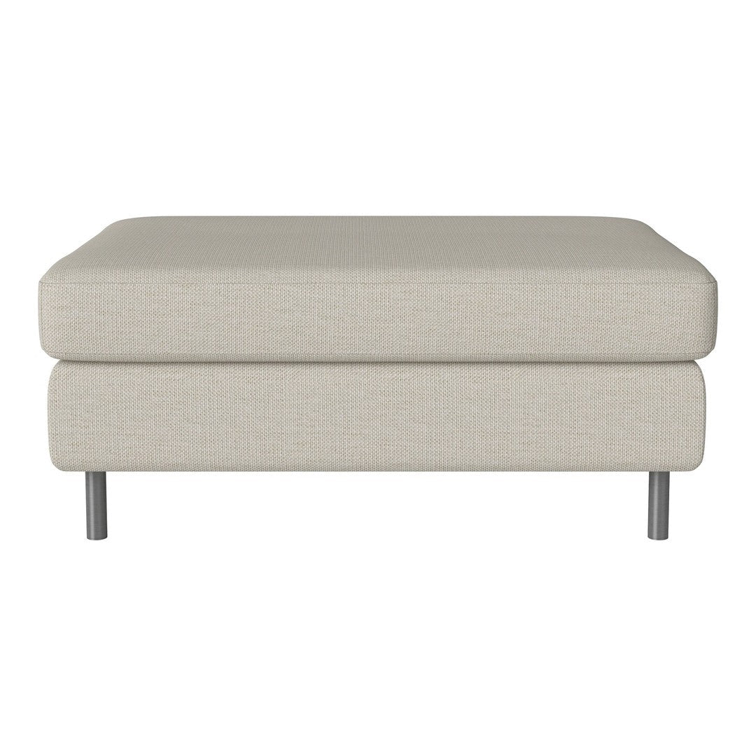 Light beige ottoman with a smooth texture and subtle fabric pattern, featuring sleek silver legs.