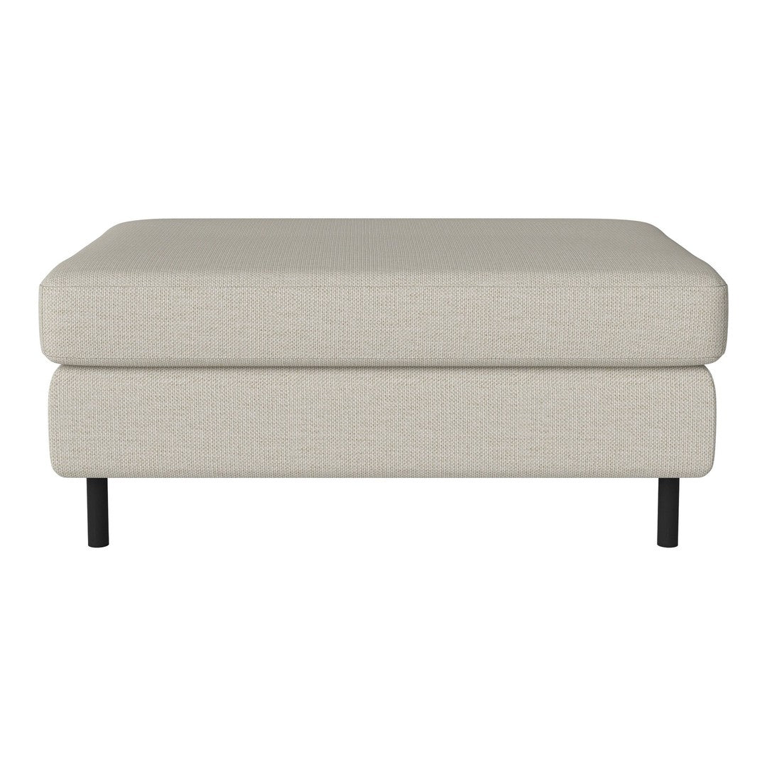 Light beige upholstered ottoman with a smooth texture and sleek black legs.