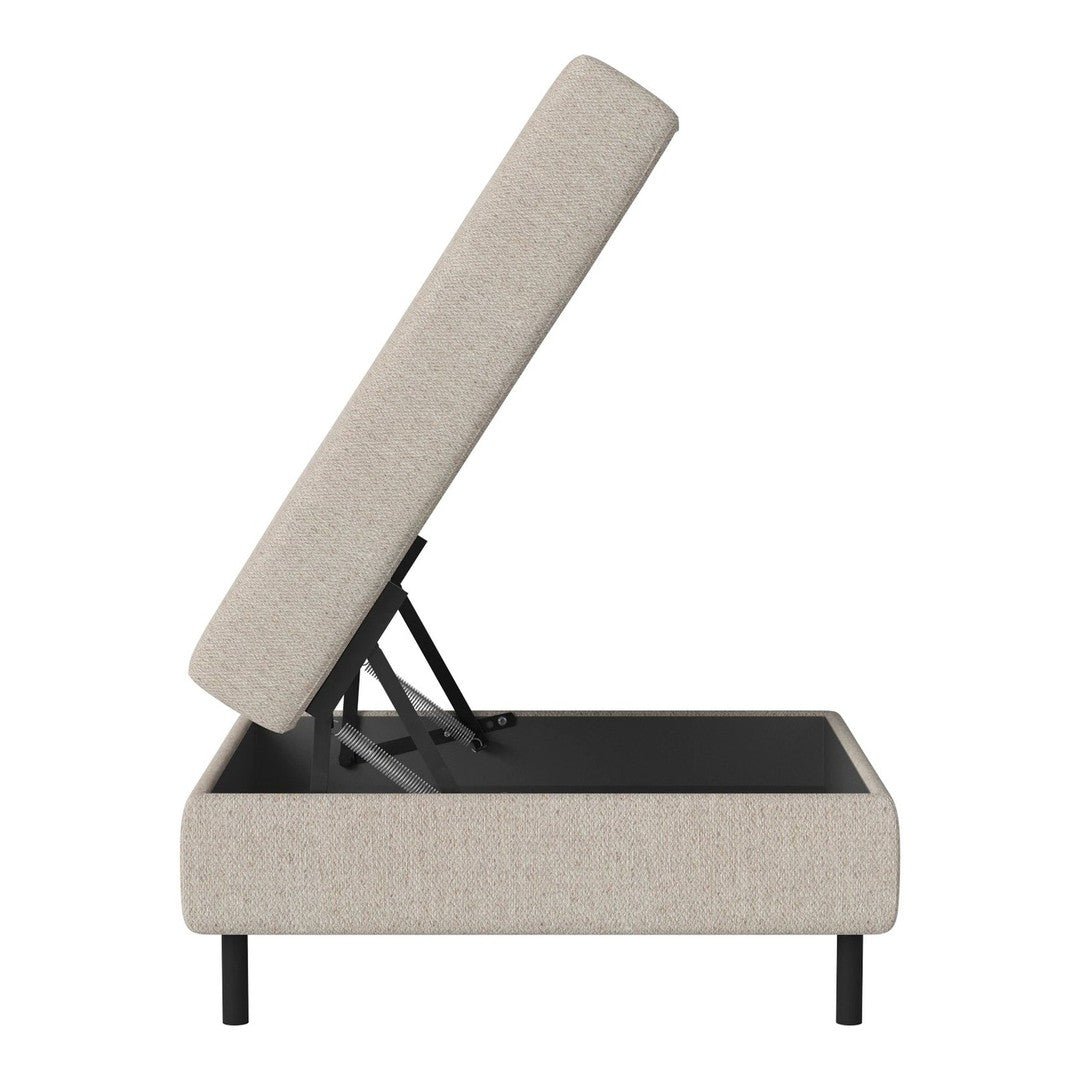 Light beige upholstered storage ottoman with a black base, featuring a simple, modern design.
