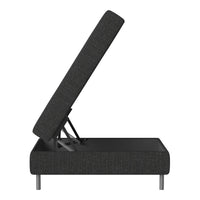 Black fabric ottoman with textured pattern, elevated to reveal storage space and minimalist silver legs.