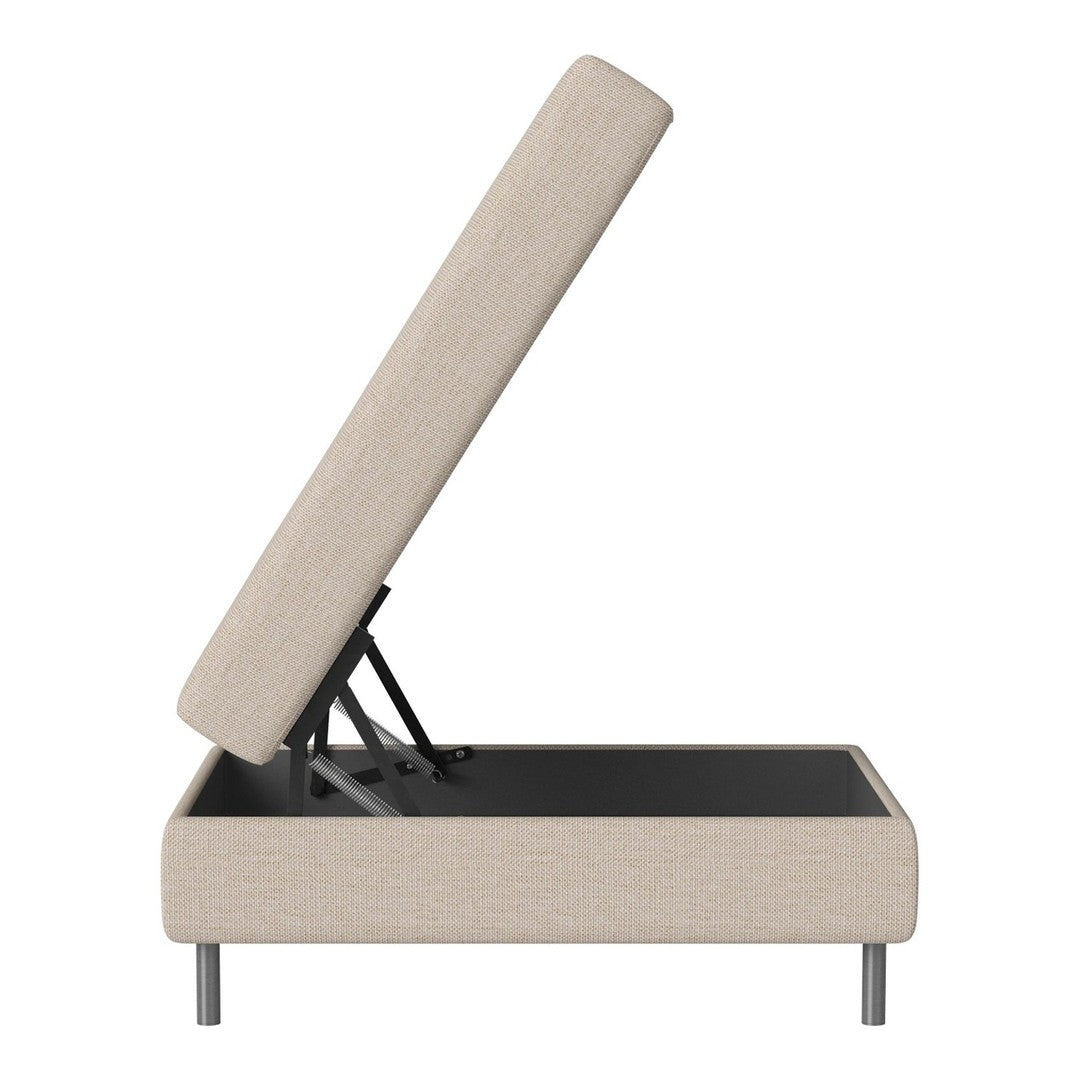 Beige upholstered ottoman with a sleek black interior and modern metal legs, showcasing minimalist design.