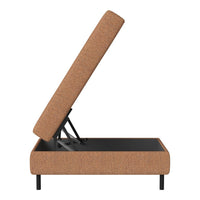 Brown fabric upholstered storage ottoman with a modern design and minimalist black metal legs.