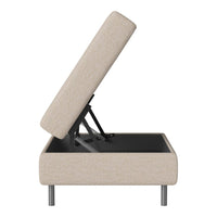 Beige upholstered storage ottoman with a clean, modern design and sleek black base. Stylish and functional accent piece.