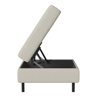 Beige upholstered storage ottoman with a sleek black base and minimalist design. Perfect for modern decor.