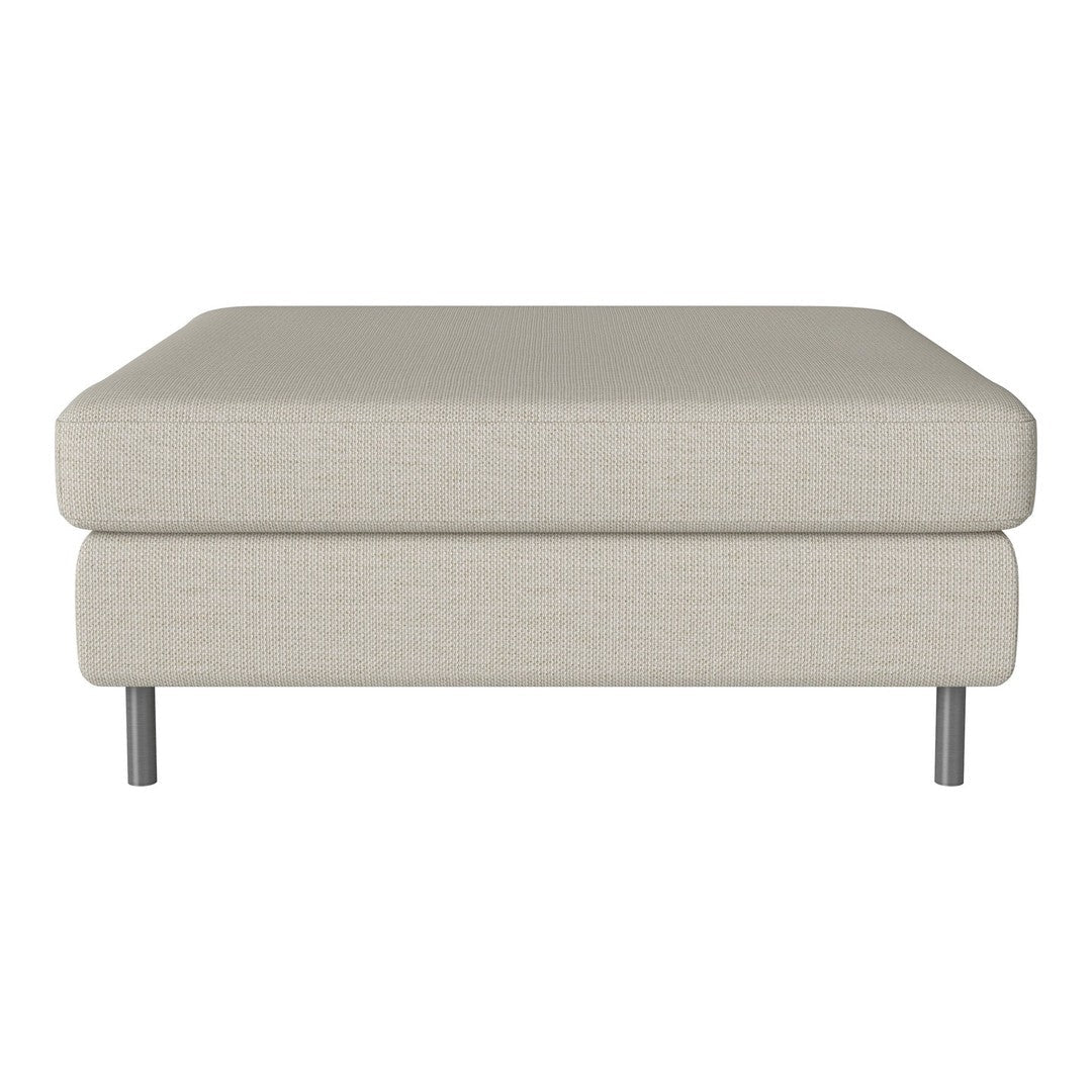 Beige upholstered ottoman with a smooth texture and sleek silver legs, perfect for modern decor.