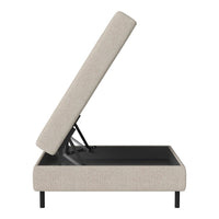 Light beige upholstered storage bed with a sleek black base and a minimalist design, positioned at an angle.