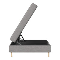 Gray upholstered storage bed with a light wood base and a sleek, minimalist design.