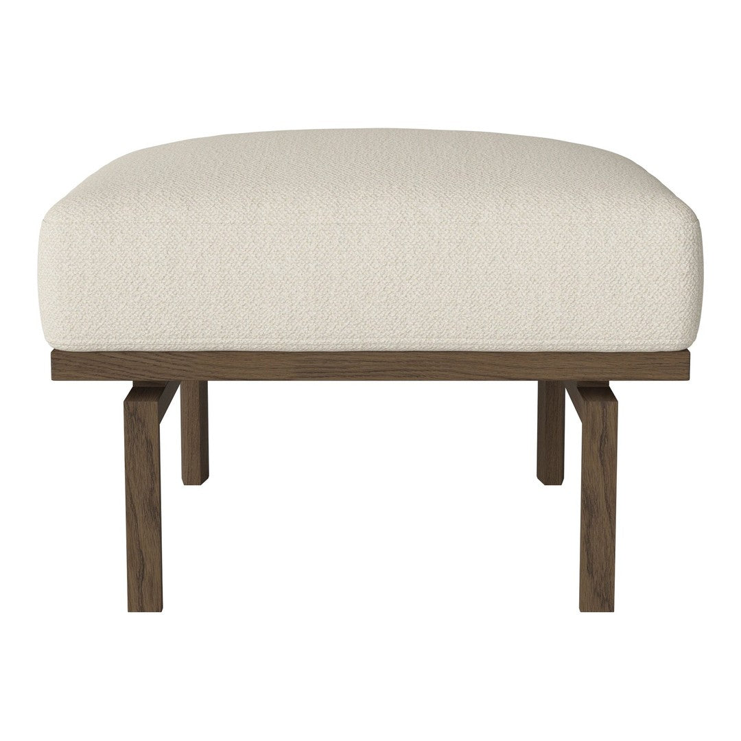 "Beige upholstered ottoman with a sleek dark wood base, featuring a modern, minimalist design."
