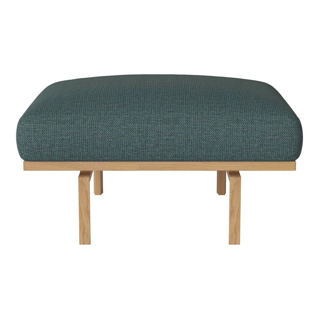 Teal upholstered ottoman with a textured pattern and natural wooden legs. Modern and stylish home decor accent.
