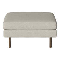 Beige upholstered ottoman with a smooth, textured surface and minimalist design, supported by slender brown legs.
