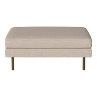 Beige upholstered ottoman with a smooth texture and minimalist design, featuring sleek metal legs.
