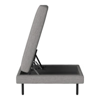 Grey upholstered adjustable bed with a minimalist design and sleek black base. Ideal for modern interiors.