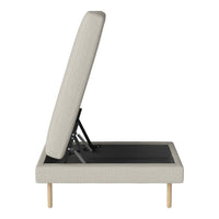 Light beige upholstered ottoman with a sleek, textured fabric and natural wood legs. Simple, modern design.