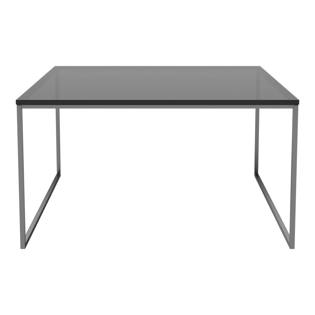 Sleek modern table with a gray glass top and minimalist silver steel legs, perfect for contemporary decor.