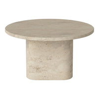 Round beige coffee table with a smooth top and textured base; minimalist design and neutral tones.