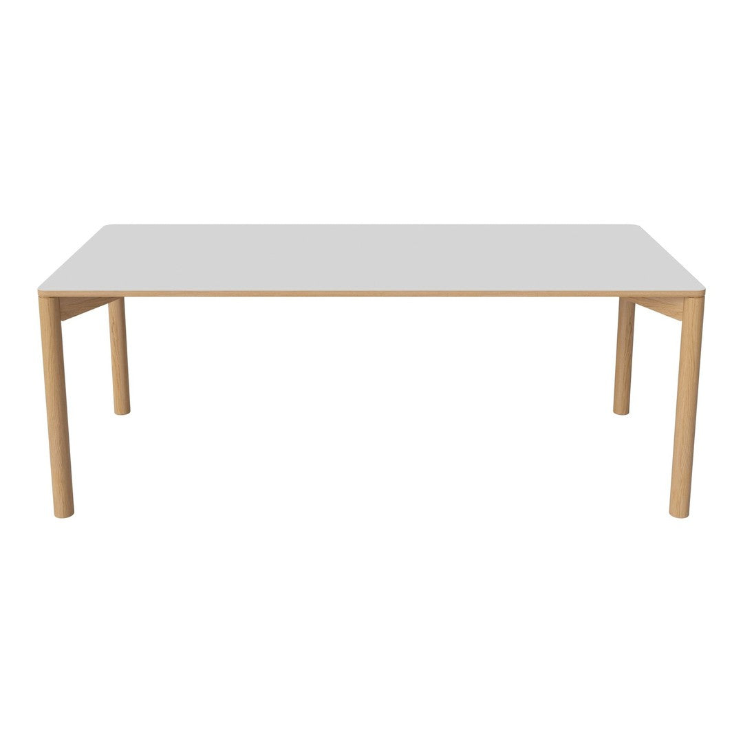 Rectangular dining table with a sleek white top and natural wood legs, perfect for modern and minimalist decor.