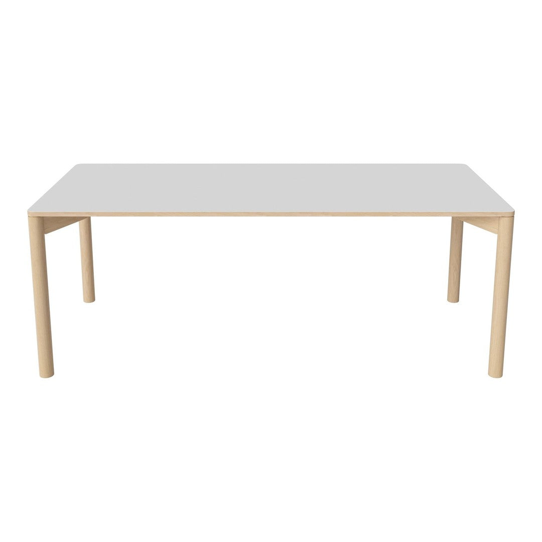 White rectangular table with natural wood legs, showcasing a clean and minimalistic design. Perfect for modern interiors.
