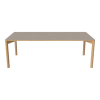 Rectangular dining table with a smooth beige surface and light wood legs, perfect for modern decor.