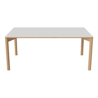 Modern rectangular table featuring a sleek white top and natural wood legs, offering a minimalist and timeless design.