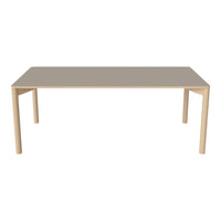 Rectangular dining table in soft beige with a smooth surface and minimalistic design, featuring light-colored legs.
