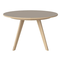 Round coffee table with a soft taupe top and natural wood legs, featuring a modern minimalist design.
