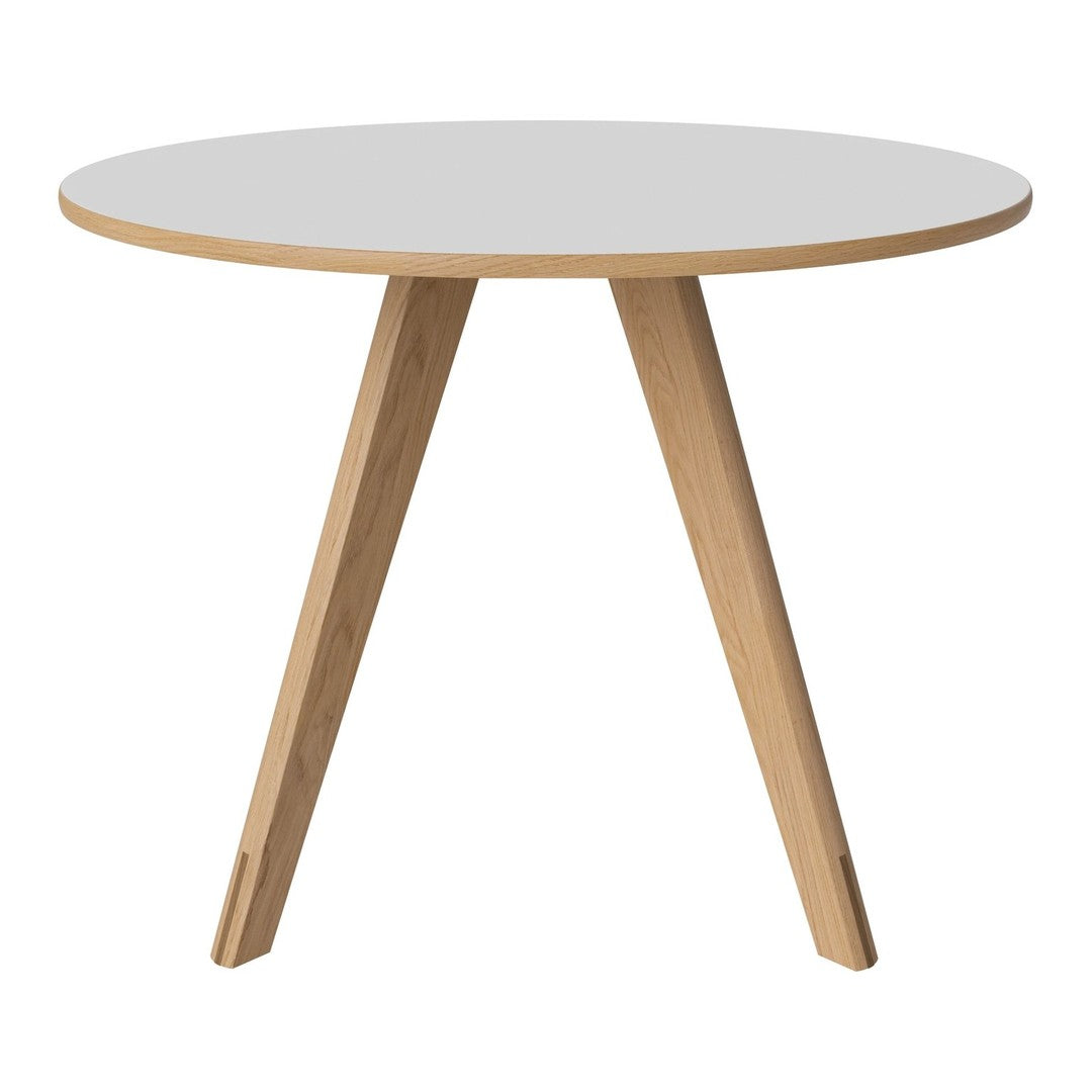 Round white tabletop with natural wood legs, featuring a minimalist design and smooth surface. Perfect for modern decor.