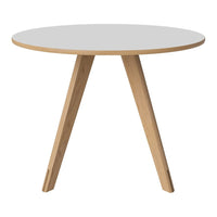 Round white tabletop with natural wood legs, featuring a minimalist design and smooth surface. Perfect for modern decor.