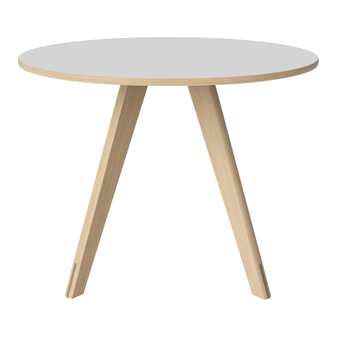 Round white table with natural wood legs, featuring a minimalist design and clean lines for modern decor.