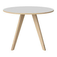 Round white table with natural wood legs, featuring a minimalist design and clean lines for modern decor.