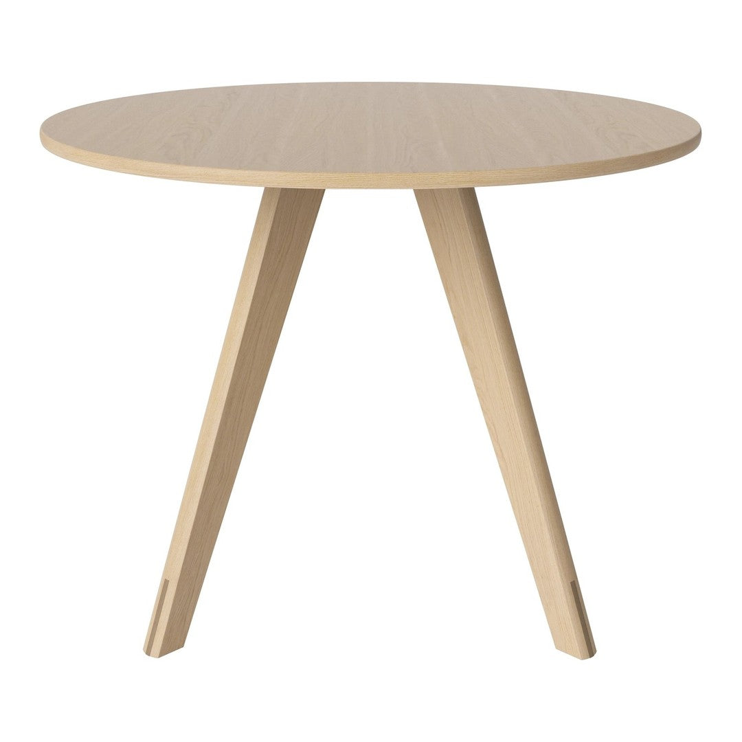 Natural wood round table with a light beige finish and simple, modern pattern in a minimalist design.