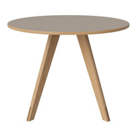 Round table with a soft gray surface and natural wood legs, featuring a minimalist design. Perfect for modern decor.