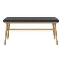 Black cushioned bench with natural wood legs, featuring a minimalist design and clean lines. Perfect for modern decor.