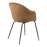 Curved brown velvet chair with black metal legs, featuring a smooth, minimalist design. Perfect for modern decor.