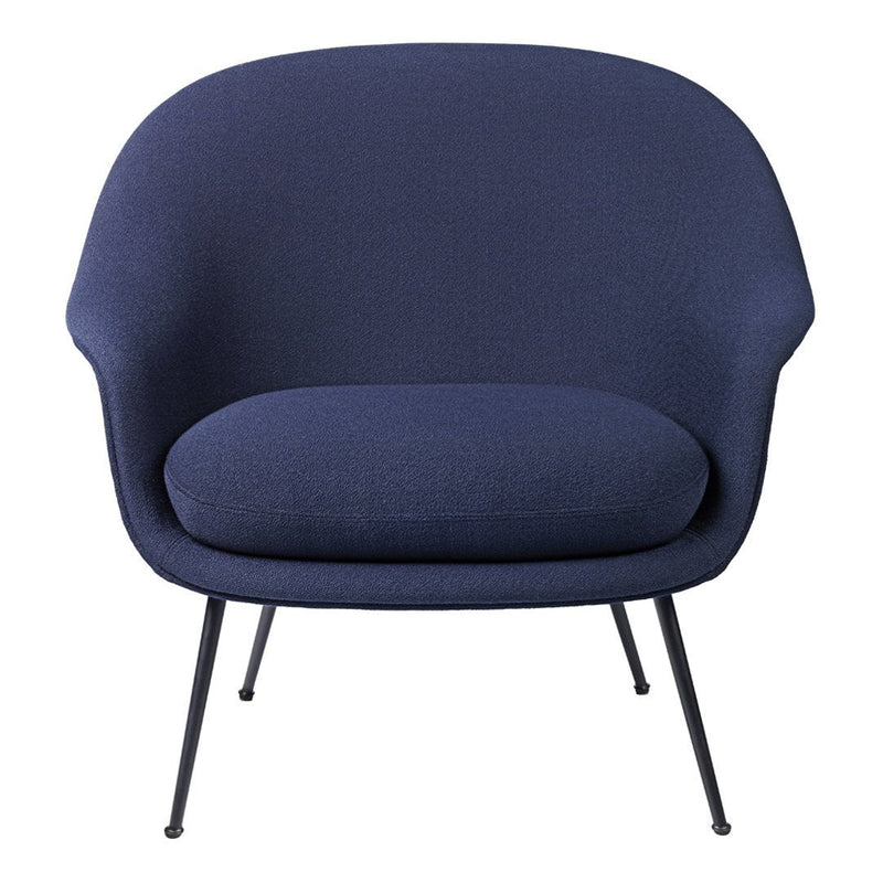 Navy blue armchair with a smooth, rounded design and subtle texture on fabric upholstery, featuring sleek black metal legs.
