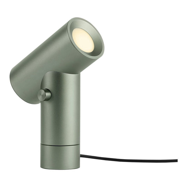 Modern green metallic table lamp with sleek design and circular light source. Simple, minimal aesthetic and black cord.