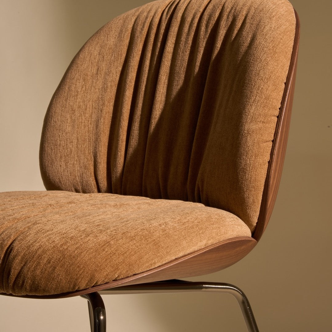 Brown upholstered chair with a ribbed texture and smooth wooden base, blending modern design with subtle elegance.
