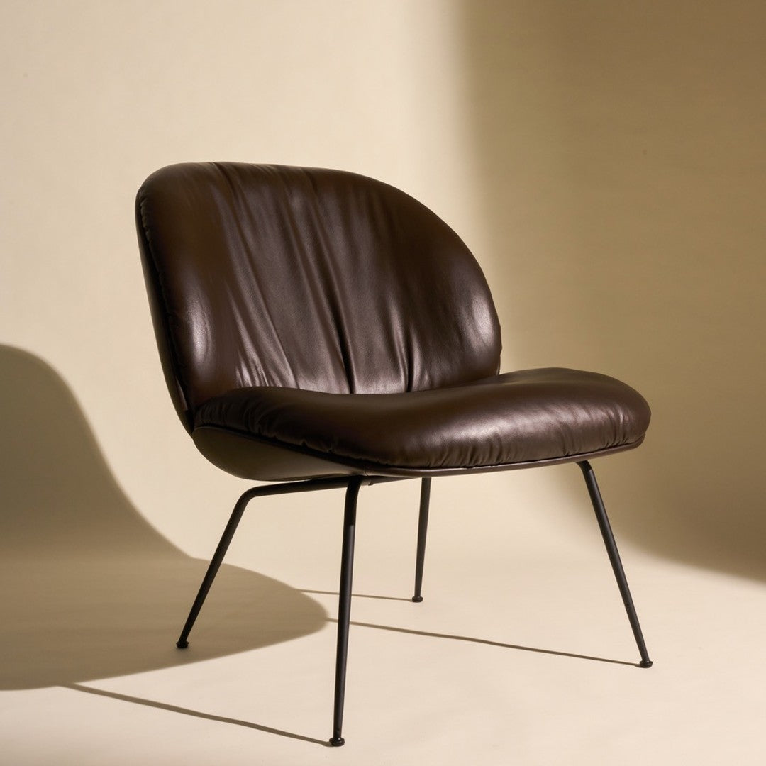 Brown leather chair with a sleek, modern design and black metal legs against a neutral background.