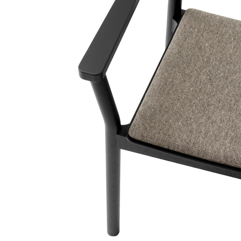 Black armchair with a textured, light gray fabric cushion, featuring a minimalist design and clean lines.