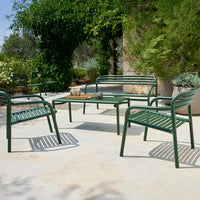 Green outdoor seating set featuring striped patterns and a sleek, modern design on a neutral patio surface.