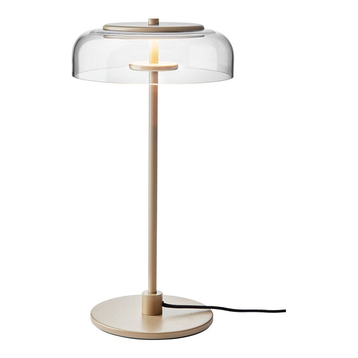 Beige lamp with a transparent dome shade and a minimalist design, featuring a smooth, round base.