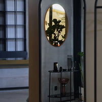 "Stylish oval mirror with a gold frame reflecting a modern interior with neutral tones and green plant accents."