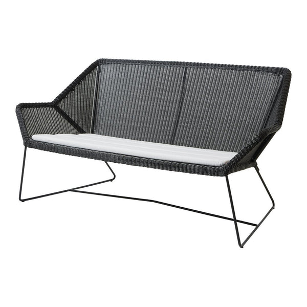 Black woven loveseat with a sleek modern design and contrasting white cushion. Ideal for stylish outdoor spaces.